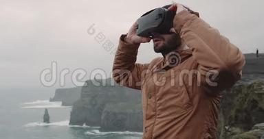 一个年轻的玩具在悬崖顶上玩VR的肖像，有着惊人的景观，他穿着VR给人留下了很深的印象